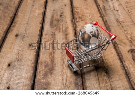 Market. Glass globe in the shopping trolley global market concept