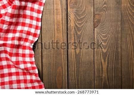 Top. Old wooden table with red picnic tablecloth and copyspace