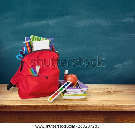 Apple. Purple backpack with school supplies isolated on white