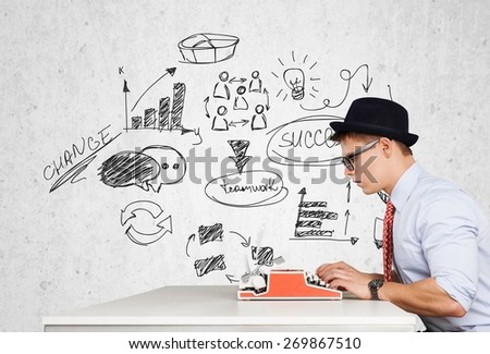 Writer. Young funny man in glasses writing on typewriter
