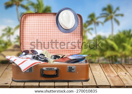 Travel. Open suitcase with hat and sunglasses