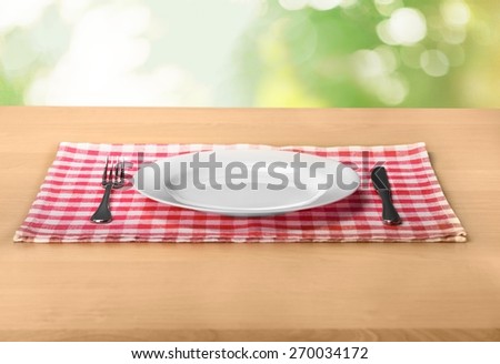 Plate. Empty plate with silverware on wooden table over bokeh background