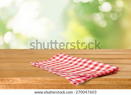 Picnic. Empty table with tablecloth over beautiful meadow and blue sky