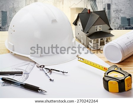 Concept. Safety helmet blue print plan and construction equipment on architect ,engineer working table with building construction  crane background use for construction industry business and civil