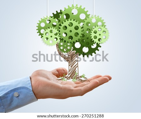 Concept. Hand hold green tree of industrial gear, environmental concept