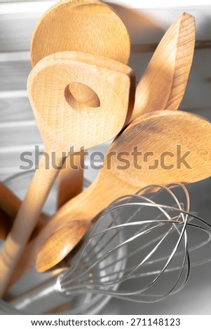 Background. Wooden spatulas and spoons; in glass container against rustic wall; good copy space