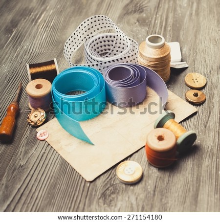 Craft. Scrapbooking craft materials/ Background with sewing tools and colored tape/Sewing kit. Scissors, bobbins with thread and needles on the old wooden background