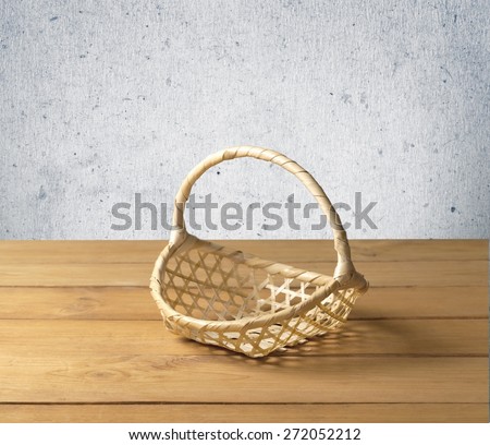 Tablecloth. Background with wooden deck tabletop and empty basket against grunge wall