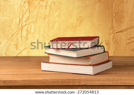 Book. Vintage old books on wooden deck tabletop against grunge wall