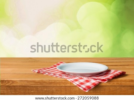 Plate. Empty white plate on wooden table over red grunge background