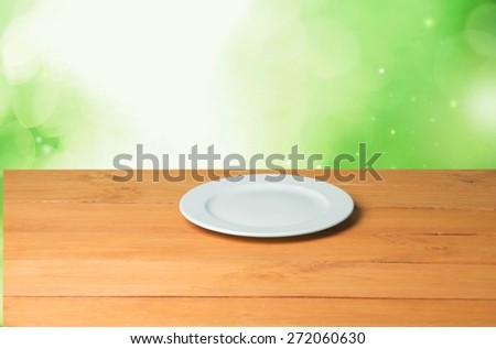Plate. Empty plate on wooden table over nature background