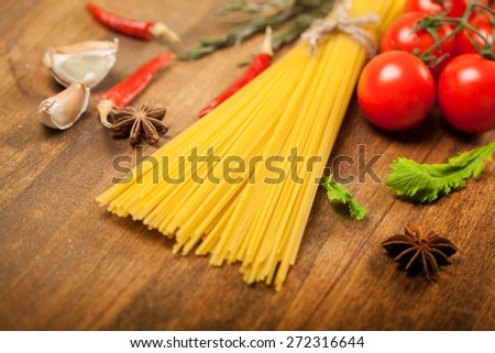 Pasta. Spaghetti and tomatoes with herbs on an old and vintage wooden table