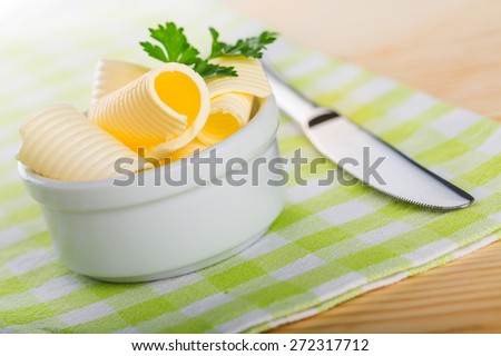 Butter. Rolled creamy butter shavings in an individual little white china ramikin for a formal catered dinner or event