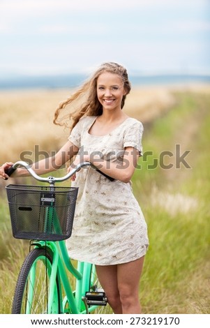 Bike. Pretty young woman riding bike in a country road.