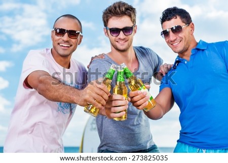 Beer. Group of Boys Cheering at Beach