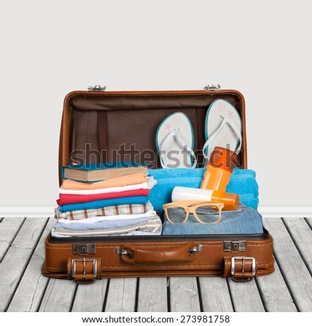 Travel. Packed vintage suitcase full of vacation items