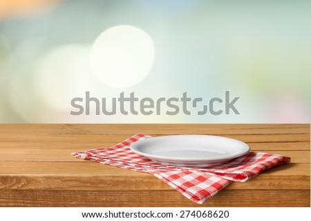 Plate. Empty white plate on wooden table over red grunge background