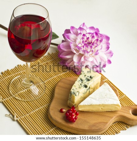 Fruit wine and cheeses on the wooden plate