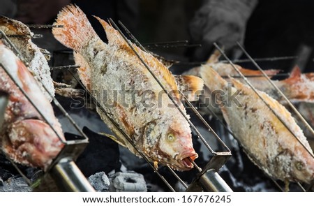 Fish(Nile Tilapia) covered by salt grill on the stove.