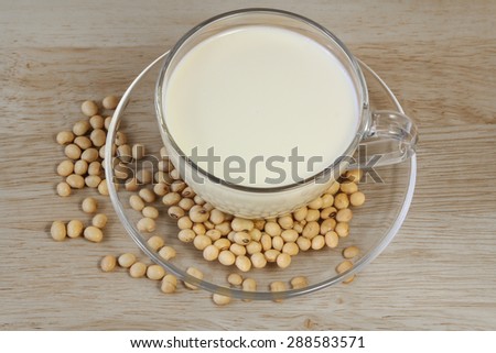 Soybeans and soy milk in a cup on wooden background