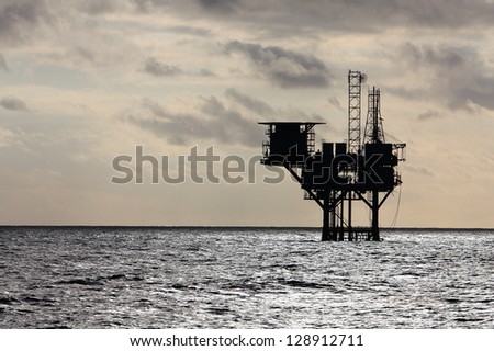 Silhouette of an oil production platform deep in the Gulf of Mexico