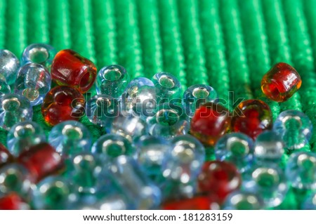 The scattered beads of red and gray color on a green background