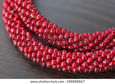 Knitted necklace from red beads close up