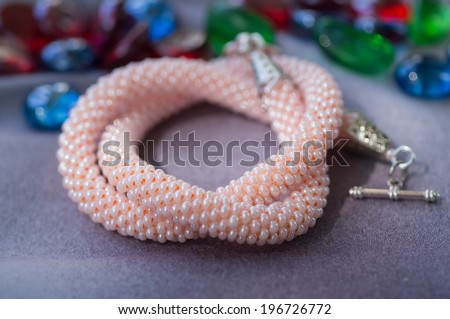 Knitted necklace from beads of pink color