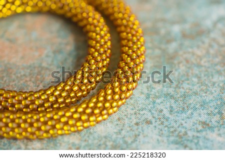 Fragment of a knitted necklace from brilliant yellow beads