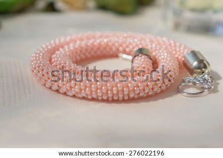Pink necklace from beads on a textile background
