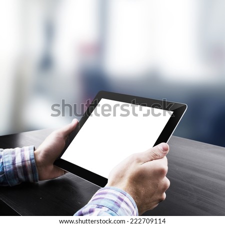 Hand holding tablet in office