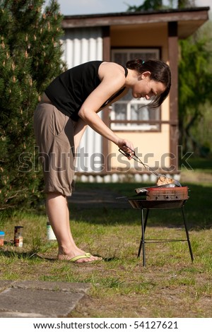 young woman and barbecue, grill, preparing some tasty food, meat