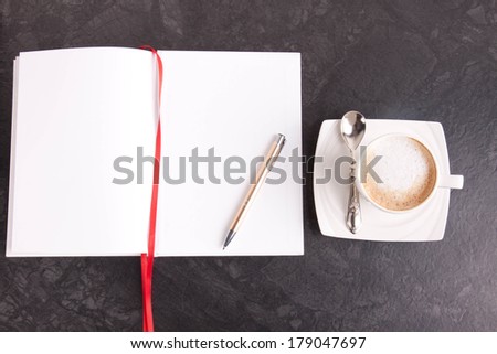 Leave a message. Coffee next to an empty notebook ready for a note