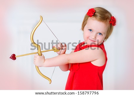 A pretty white little girl as the cupid with a bow and an arrow congratulating on St\' Valentine\'s day