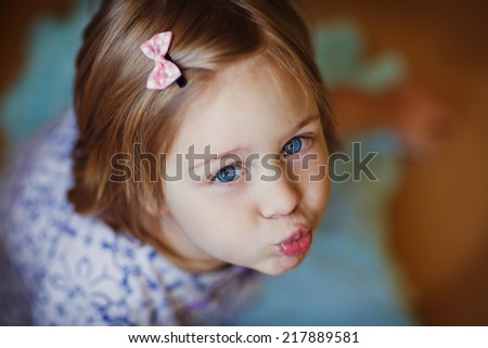 A little cute girl blowing kisses close up.