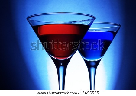 Red and blue cocktails on blue background, close up