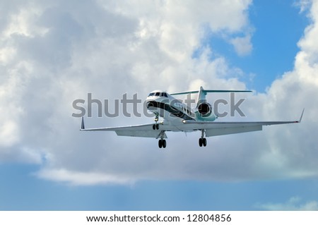 Private Corporate Business Jet close to landing. Blue cloudy sky.