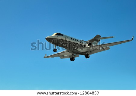 Private Corporate Business Jet close to landing. Clear blue sky.