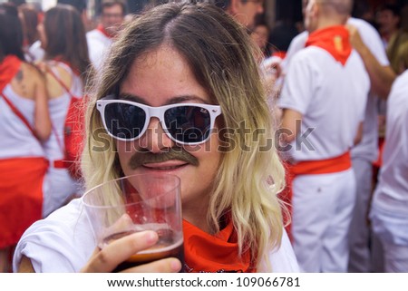 PAMPLONA, SPAIN -JULY 6:An unidentified man with a glass of red wine in hand participates at the opening of the San Fermin festival in Pamplona, Spain on July 6, 2012.