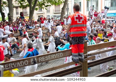 PAMPLONA, SPAIN -JULY 7: Unidentified men run from the bulls in front plaza Toros during the San Fermin festival in Pamplona, Spain on July 7, 2012.