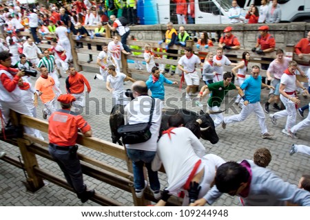 PAMPLONA, SPAIN -JULY 8: Unidentified men run from the bulls in front plaza Toros during the San Fermin festival in Pamplona, Spain on July 8, 2012.