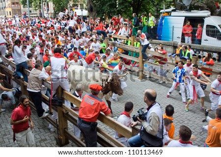 PAMPLONA, SPAIN -JULY 8: Unidentified men run from the bulls in front plaza Toros during the San Fermin festival in Pamplona, Spain on July 8, 2012.