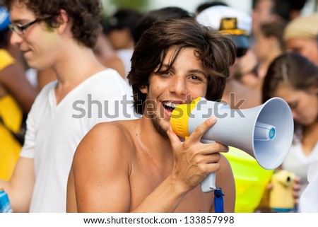 RIO DE JANEIRO - FEBRUARY 11: Young men with megaphone having fun on the free people\'s carnival in Rio de Janeiro February 11, 2013, Brazil. Av. Vieira Souto along Ipanema Beach