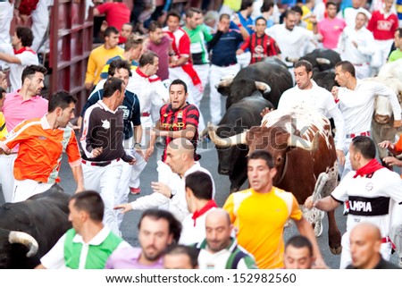 MADRID SUBURB OF SAN SEBASTIAN DE LOS REYES - SEPT. 30, 2013 : Men run from the bulls on the street of San Sebastian de los Reyes during festival, Spain 2013. Fiesta called 