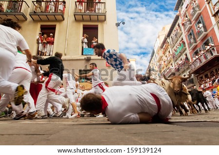 PAMPLONA, SPAIN-JULY 12: People run from bulls on street during San Fermin festival in Pamplona, Spain on July 12, 2013..
