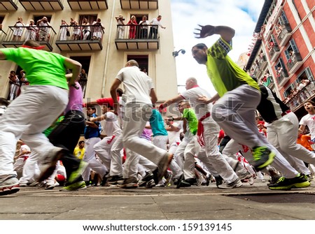 PAMPLONA, SPAIN-JULY 13: People run from the bulls on the street during San Fermin festival in Pamplona, Spain on July 13, 2013..