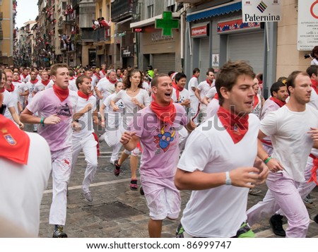 PAMPLONA, SPAIN -JULY 7: Unidentified men run from the bulls in the street Estafeta during the San Fermin festival in Pamplona, Spain on July 7, 2011.