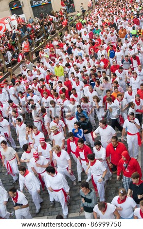 PAMPLONA, SPAIN -JULY 8: A crowd of unknown people in anticipation of beginning a run of bulls in the street Estafeta at the festival of San Fermin in Pamplona, Spain on July 8, 2011.