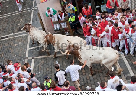 PAMPLONA, SPAIN -JULY 8: Unidentified men run from the bulls in the street Estafeta during the San Fermin festival in Pamplona, Spain on July 8, 2011.