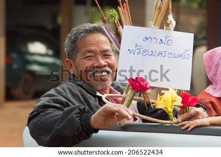 PROVINCE LOEI, THAILAND - FEBRUARY 16: A man rides a village wedding in province Loei, Thailand, February 16, 2014. Guests give newlyweds money on special sticks